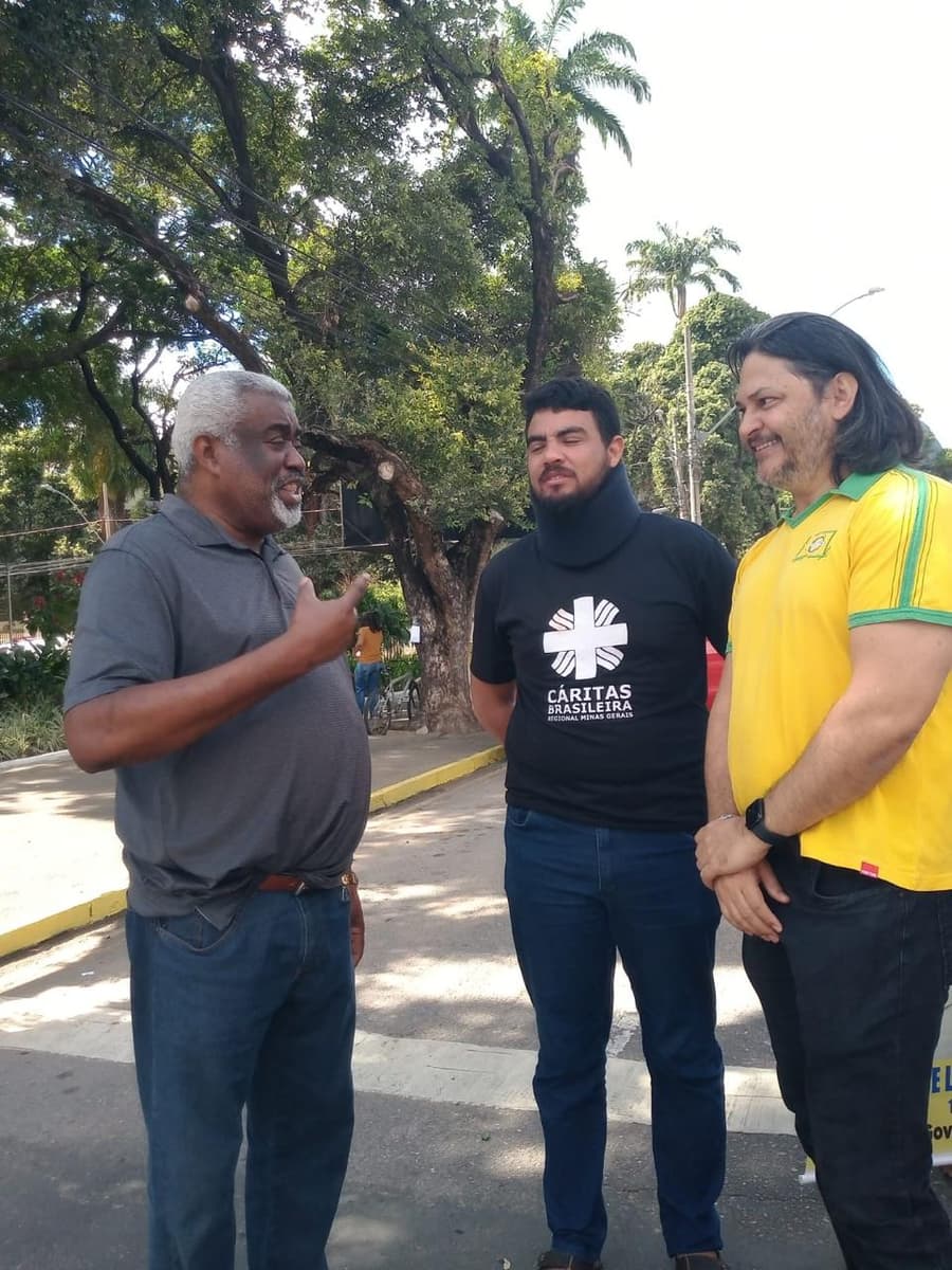 Cézar Ribeiro conversa com dois participantes durante um ato de rua em Governador Valadares